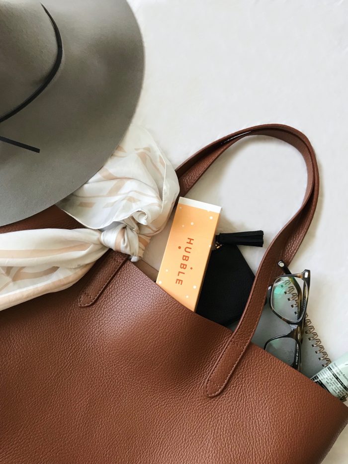 A brown purse and grey hat
