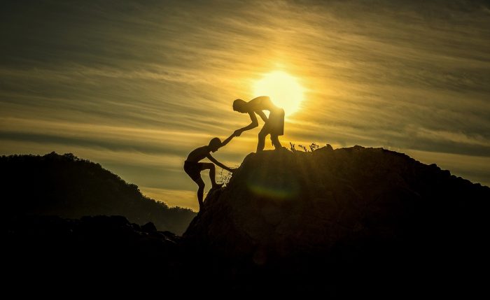Two boys hiking a mountain during sunset